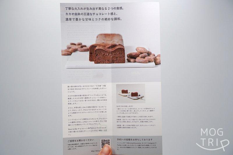 ビーントゥバーチョコレート専門店 Minimal（ミニマル）の生ガトーショコラの解説書を手に持っている様子