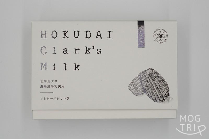 北海道大学の敷地内にある北大マルシェ の「HOKUDAI Clark's Milk マドレーヌ ショコラ」の箱がテーブルに置かれている