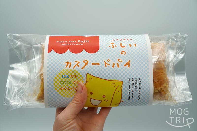 倶知安 お菓子のふじいの冷凍カスタードパイ 2個入を手に持っている様子