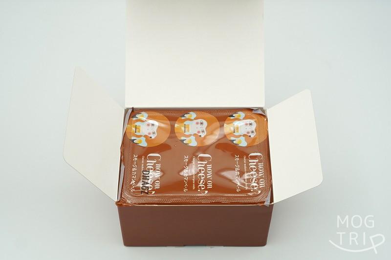 ふたを開けたナウオンチーズの東京駅限定品 スモーク＆カマンベールクッキーの箱がテーブルに置かれている