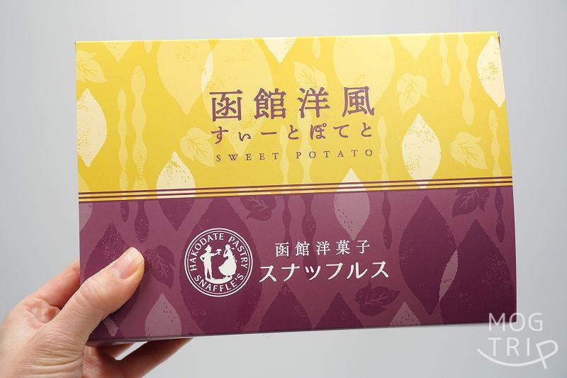 函館洋菓子スナッフルスの「函館洋風すいーとぽてと」の箱を手に持っている様子