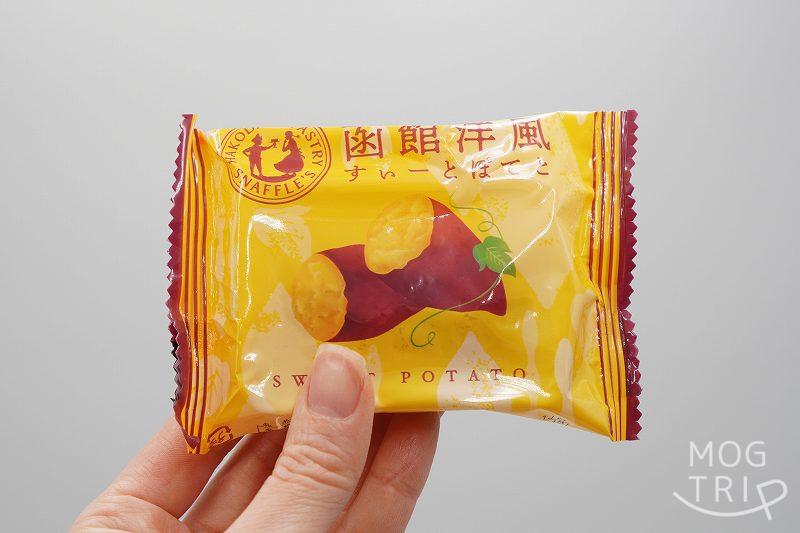 袋に入った函館洋菓子スナッフルスの「函館洋風すいーとぽてと」を、手に持っている様子