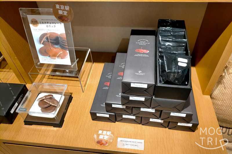 バニラビーンズ ザ ロースタリー トーキョーの、東京駅限定品「ミルクチョコレートホリック」の箱が木のカウンターの上に並べられている