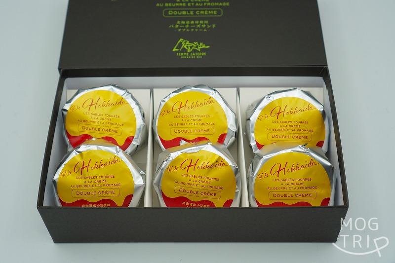 【大阪・阪急うめだ本店限定】フェルムラテール美瑛の「バターチーズサンド（小豆バター） 6個入」の箱が、ふたを開けた状態でテーブルに置かれている