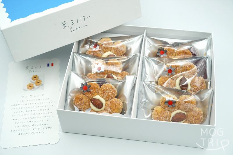 東京駅・大阪限定スイーツ・薫るバターSabrina（サブリナ）の「サブリナ」の箱が、ふたを開けた状態でテーブルに置かれている