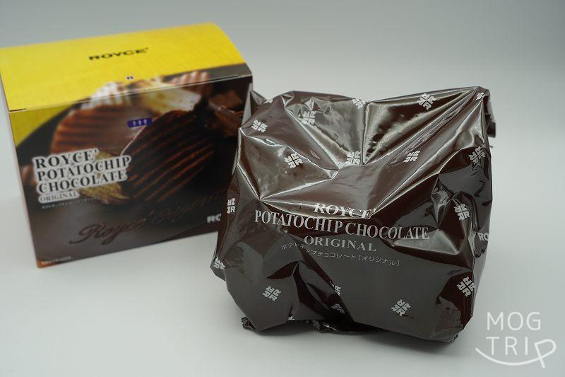 ROYCE’（ロイズ）のポテトチップチョコレートの箱と袋がテーブルに置かれている