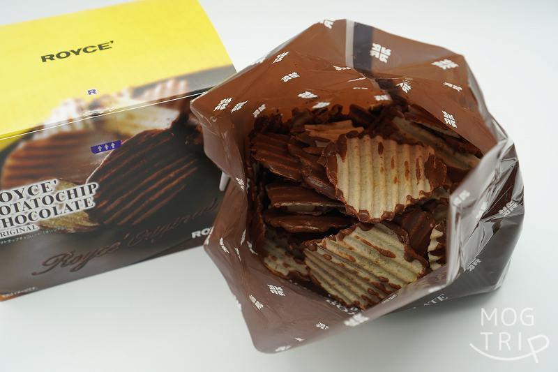 袋を開けたROYCE’（ロイズ）のポテトチップチョコレートが、テーブルに置かれている