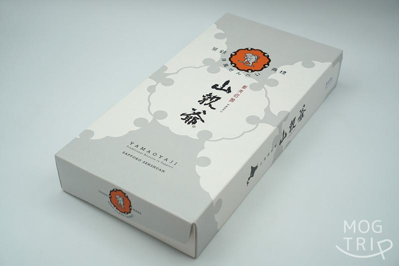 札幌千秋庵製菓の旧パッケージデザインの「山親爺」の箱がテーブルに置かれている