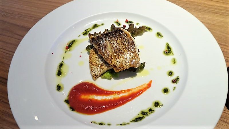 「CAFE ＆ RESTAURANT ORGALI（オーガリ）」の魚料理・鯛のポワレがテーブルに置かれている