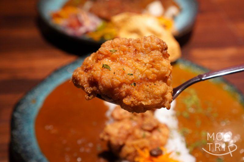 E-itou Curry（エイトカリー）のあべ鶏の唐揚げのザンギをスプーンで持ち上げている様子