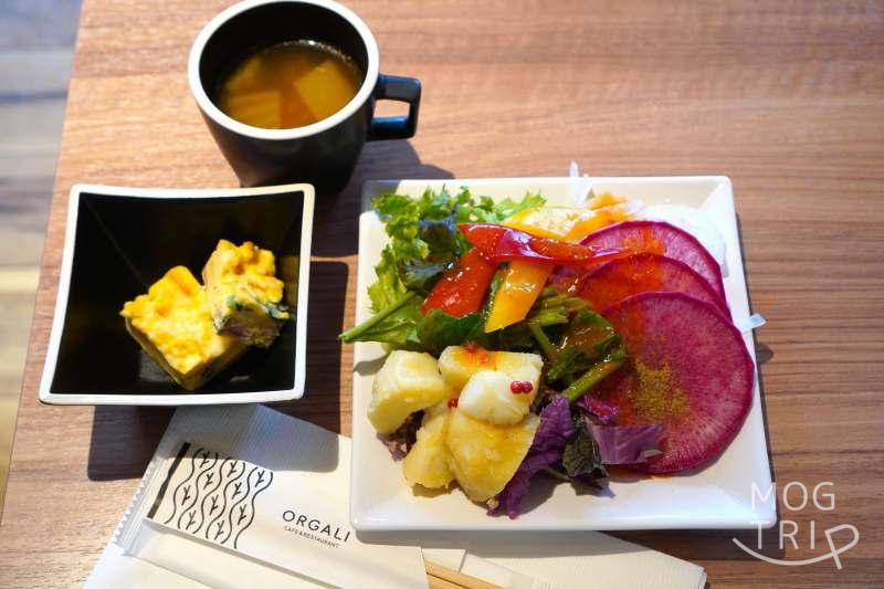「CAFE ＆ RESTAURANT ORGALI（オーガリ）」のサラダや前菜がテーブルに置かれている