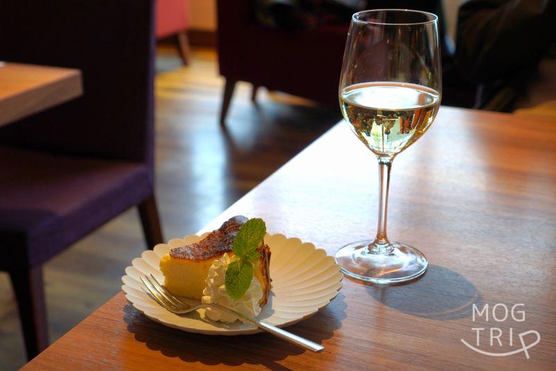 「CAFE ＆ RESTAURANT ORGALI（オーガリ）」のバスクチーズケーキと白ワインがテーブルに置かれている