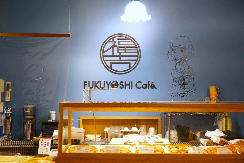 壁に漫画家のサインが書かれている福吉カフェ 旭橋本店の内観