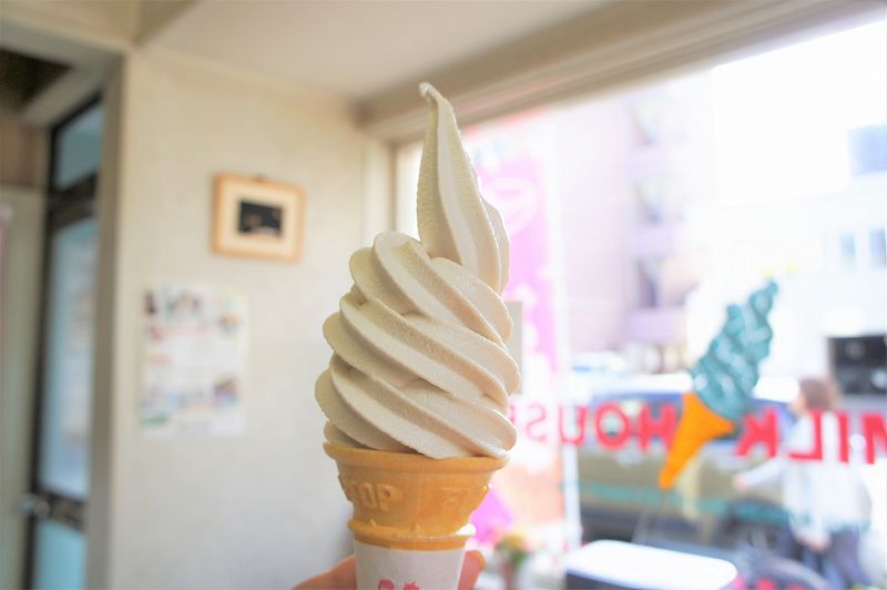 札幌ミルクハウス本店のカフェオレソフトクリームを手に持っている様子