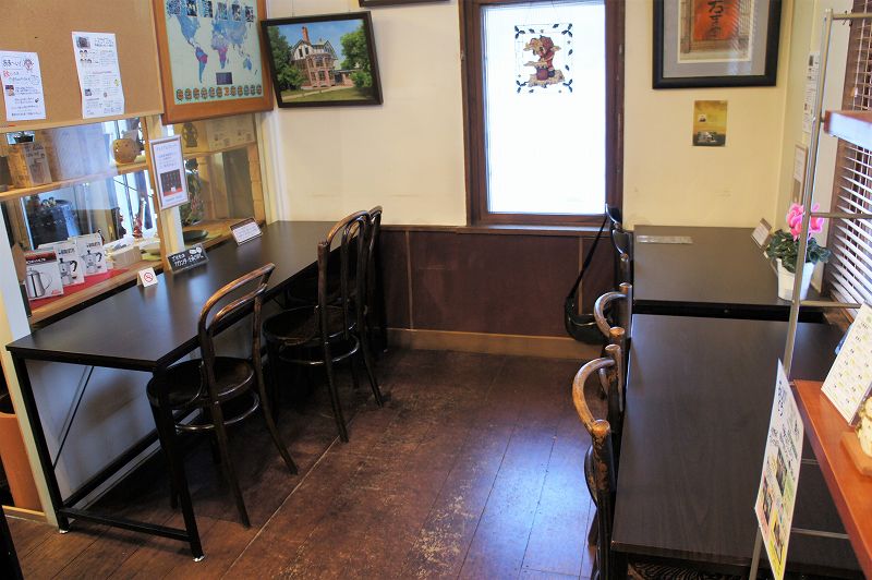 濃い茶色の木を基調としたテーブルとイスが並ぶ、「ノースライブコーヒー」の店内