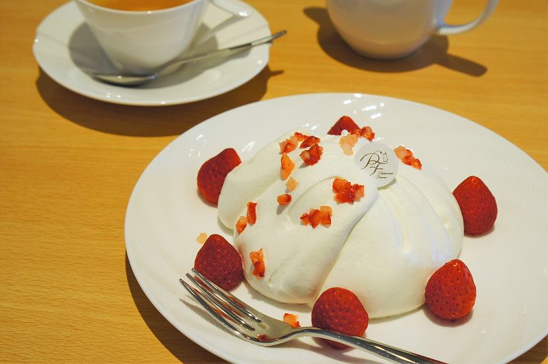 生クリームにおおわれた苺のケーキと紅茶が、テーブルに置かれている