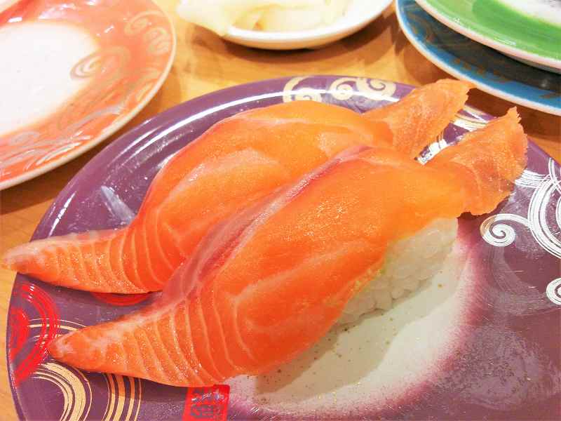 「生サーモン（280円）」のお寿司がテーブルに置かれている