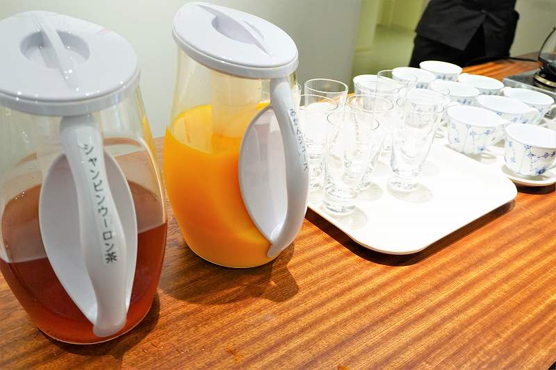 シャンピンウーロン茶とみかんジュースがテーブルに置かれている