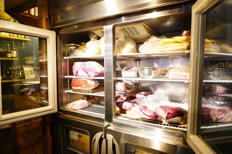 「THE MEAT SHOP（ザ・ミートショップ）」の冷蔵庫に大きな肉の塊がたくさん入っている様子