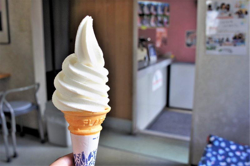 札幌ミルクハウス本店のソフトクリーム「バニラレギュラー」を手に持っている様子