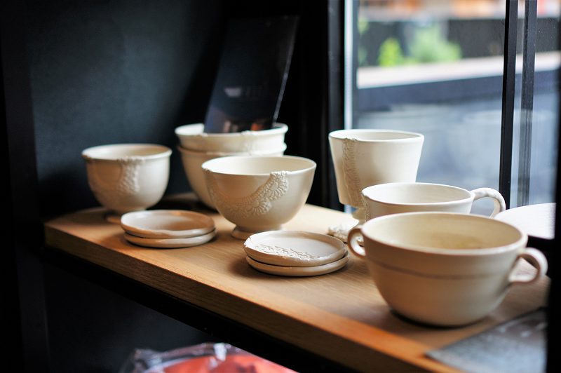 白い陶器のスープカップやプレートなどが棚に置かれている