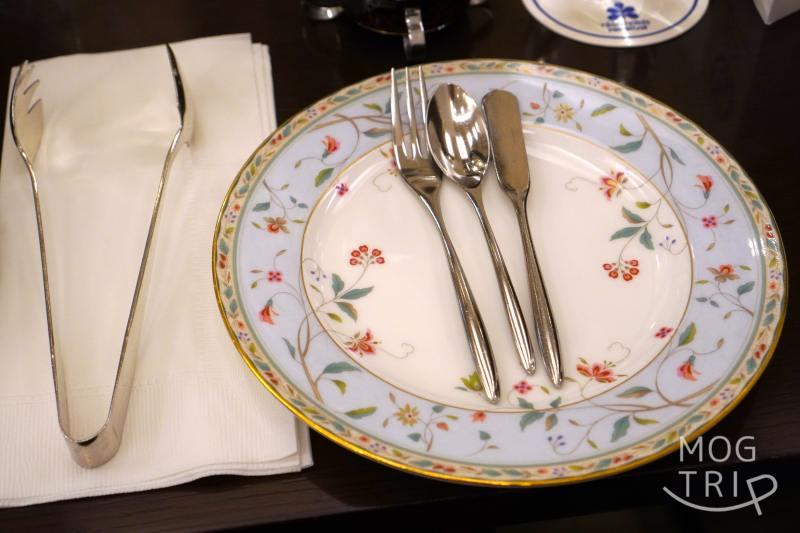 食器やカトラリーがテーブルに置かれている
