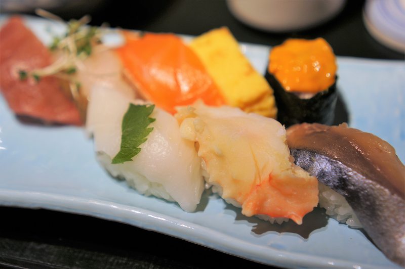 サバ、カニ、ウニなどのお寿司が皿に盛られている