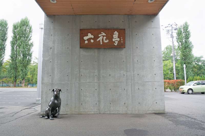 六花亭の店名看板と犬のオブジェが置かれている、六花亭真駒内六花亭ホール店の入口前