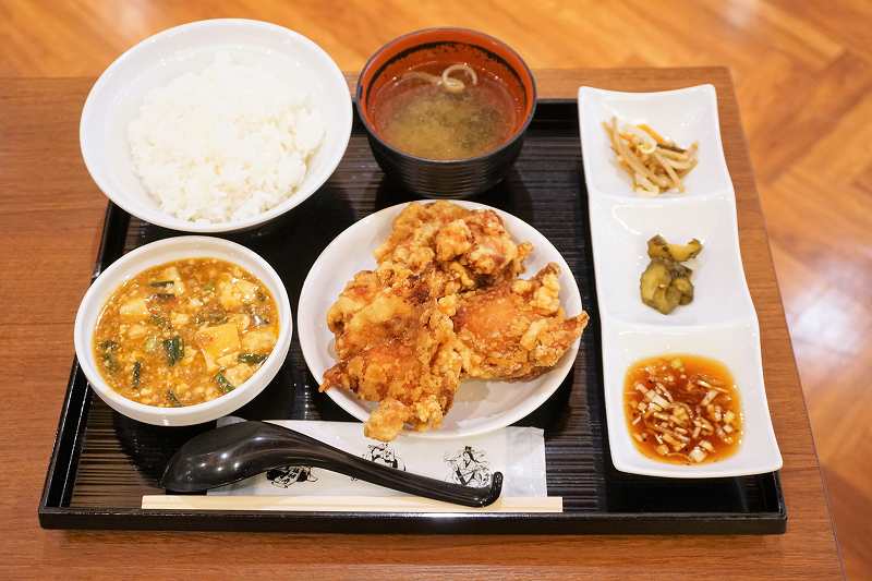 ザンギや麻婆豆腐の定食がテーブルに置かれている