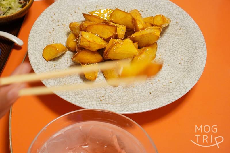 中華料理 香州（かしゅう）のイモ点心を箸で氷水にうつしている様子