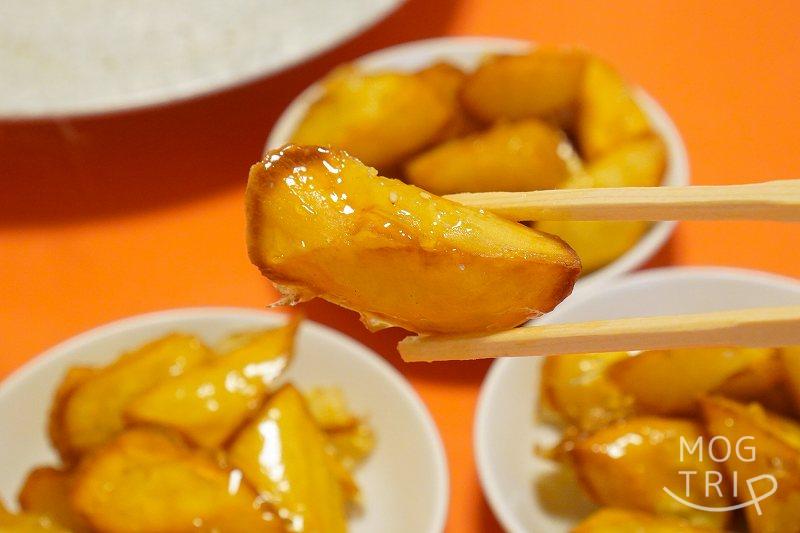 中華料理 香州（かしゅう）のイモ点心を箸で持ち上げている様子