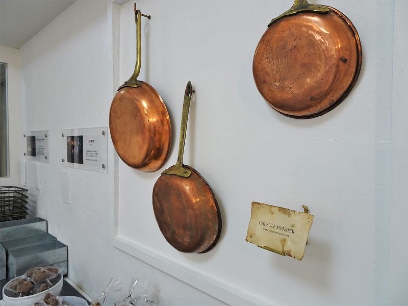 壁に銅のフライパンがディスプレイされている
