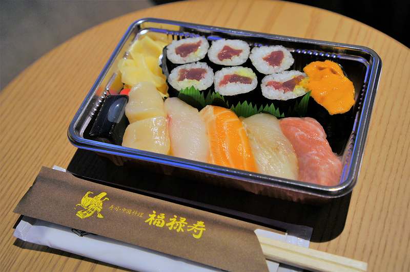 お寿司 6貫と巻物 1本がテーブルに置かれている