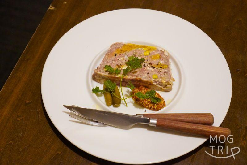 「肉×ワインビュッフェ Bistro CinqCes（ビストロ サンクシー）」のパテ・ド・カンパーニュがテーブルに置かれている