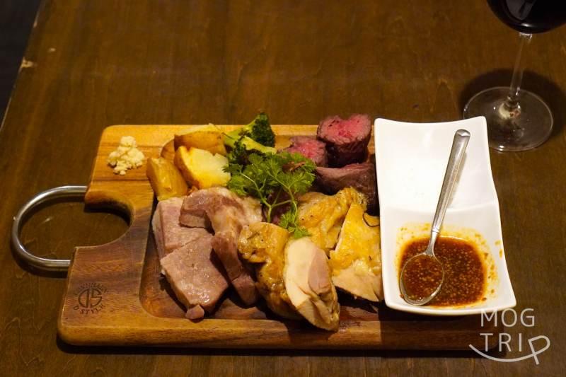 「肉×ワインビュッフェ Bistro CinqCes（ビストロ サンクシー）」のびすとろ３ミートプレートがテーブルに置かれている