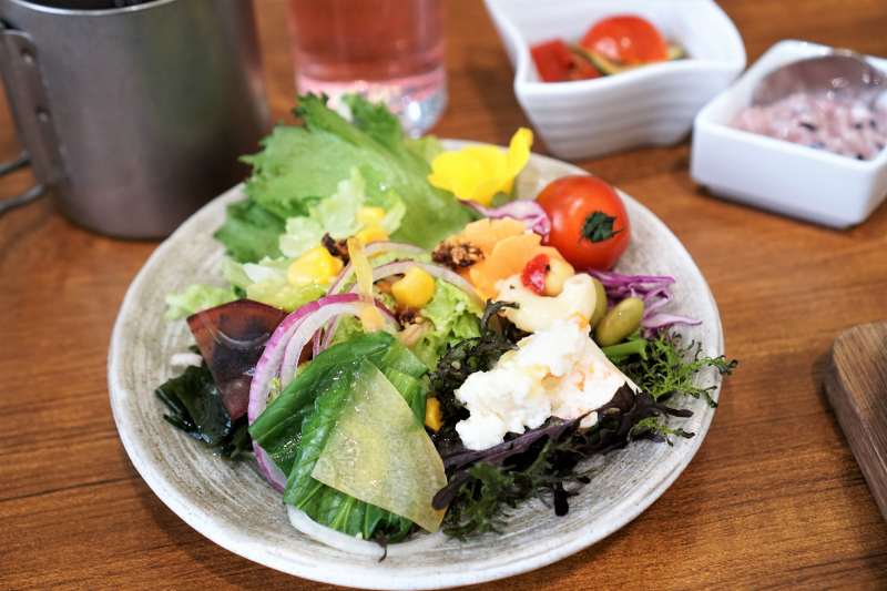 色とりどり野菜サラダやドリンクがテーブルに置かれている