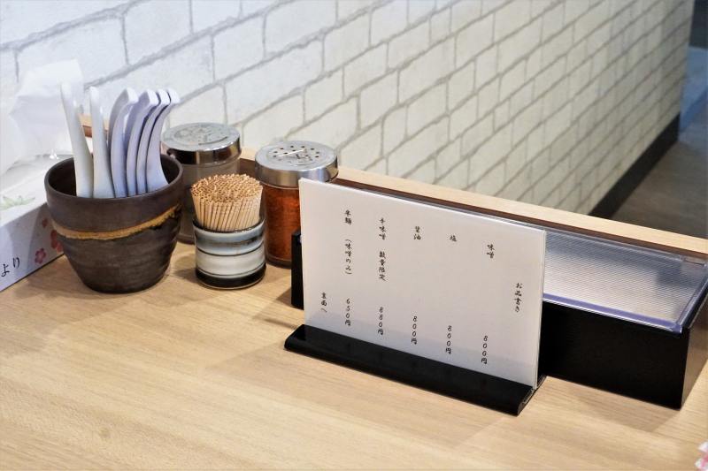 レンゲや一味などが置かれている、「札幌麺屋 美椿」のテーブル上の様子