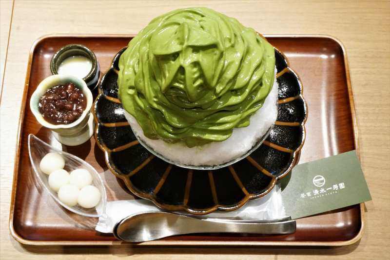 「茶匠 清水一芳園 三井アウトレットパーク札幌北広島店」の「特製宇治抹茶エスプーマかき氷」とトッピングがテーブルに置かれている