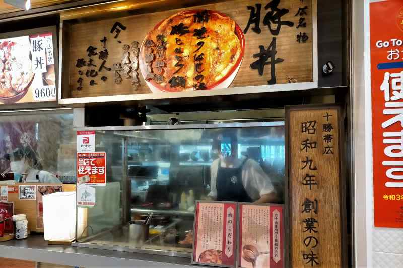 豚丼のぶたはげ北広島店の店頭で、スタッフが豚肉を焼いている様子