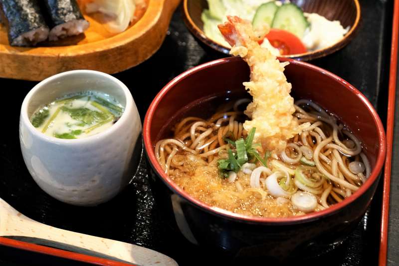 エビの天ぷらがのった蕎麦や茶碗蒸しがテーブルに置かれている