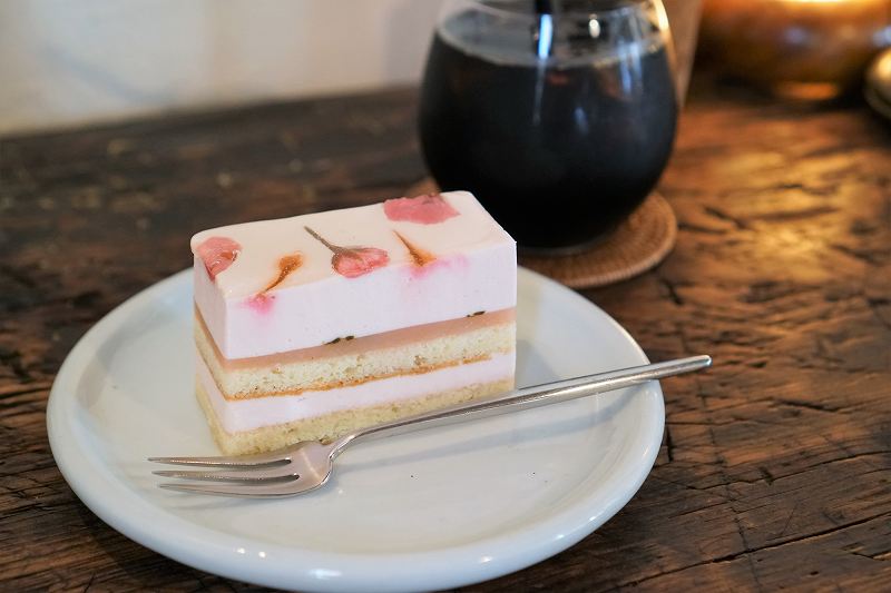 桜のケーキとアイスコーヒーがテーブルに置かれている