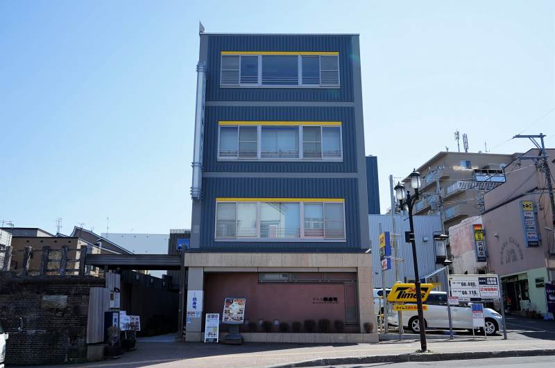 寿司屋通り沿いに建つ、ブルーの外壁のおたる政寿司本店外観