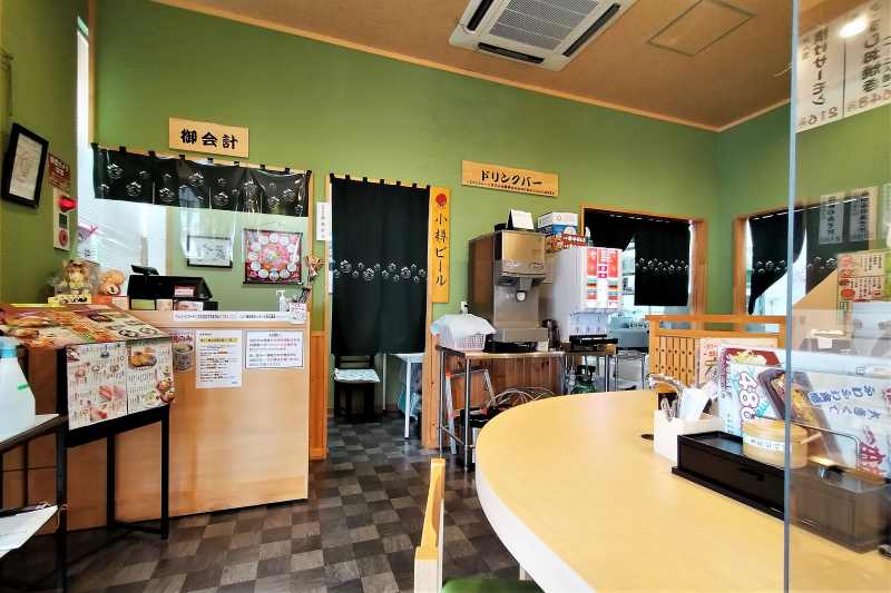 淡いグリーンの壁の「回転寿司うずしお 高島店」の内観