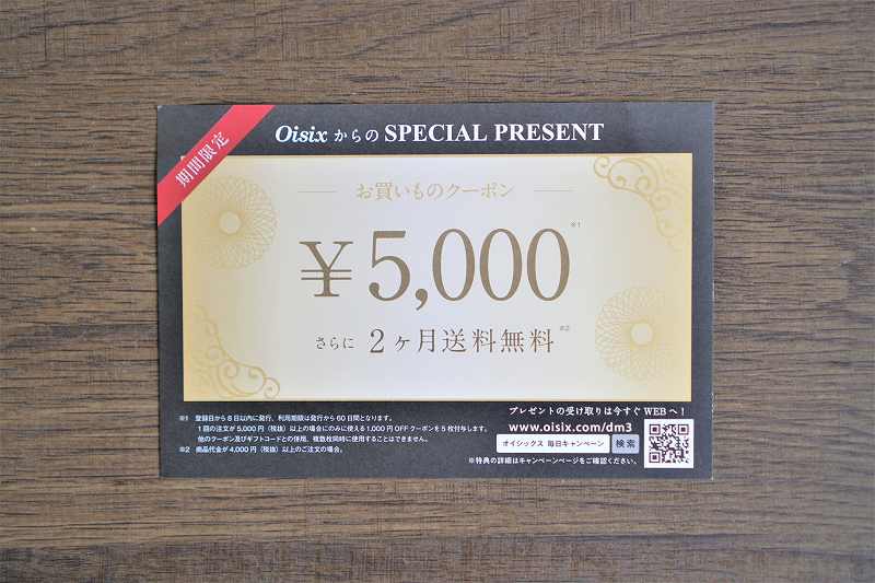 Oisixのお買い物クーポン5000円がテーブルに置かれている