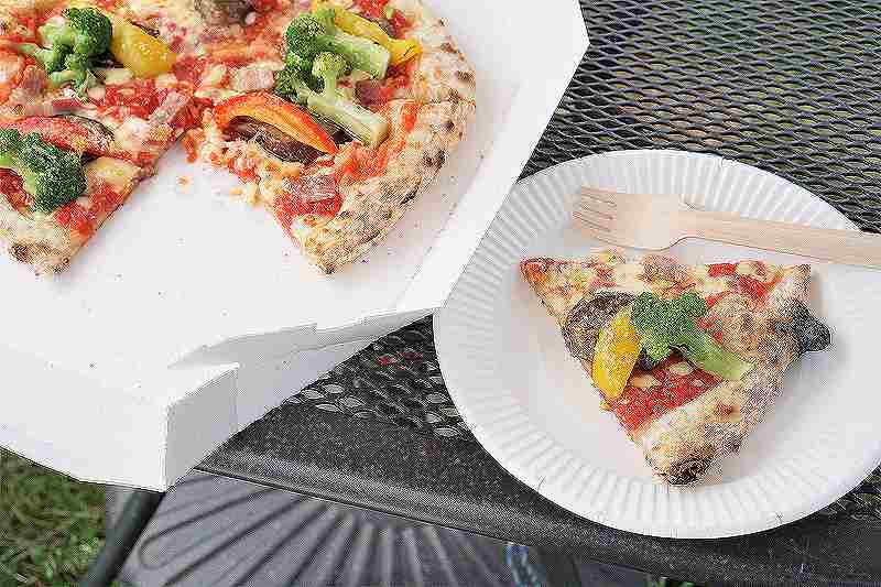 紙皿に取り分けられた夏野菜のピザがテーブルに置かれている