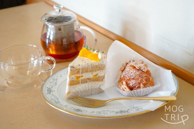 「ハレとケ洋菓子店」のケーキとシュークリームと紅茶がテーブルに置かれている