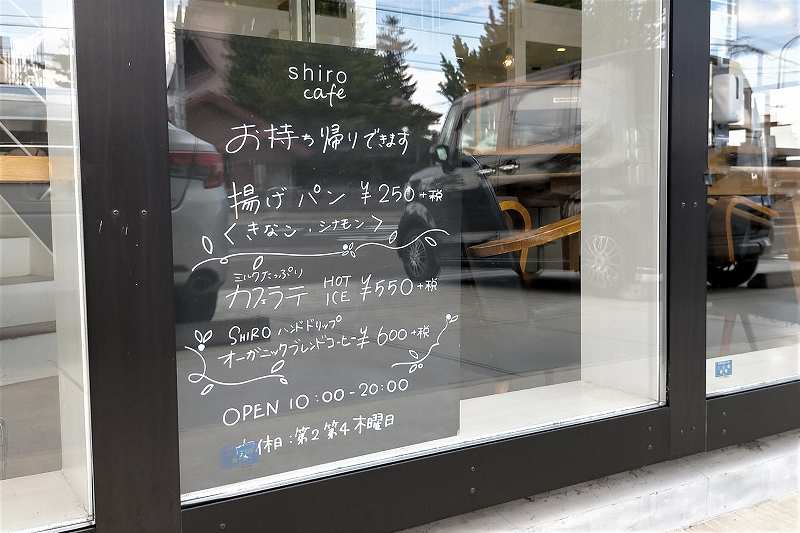 SHIRO CAFEのテイクアウトメニューが窓に立てかけられている