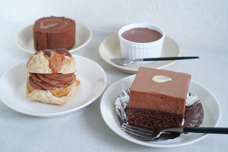チョコレートのケーキやシュークリーム、プリンがテーブルに置かれている