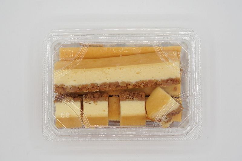 梅屋の【アウトレット品】ベイクドチーズケーキの切れ端がテーブルに置かれている