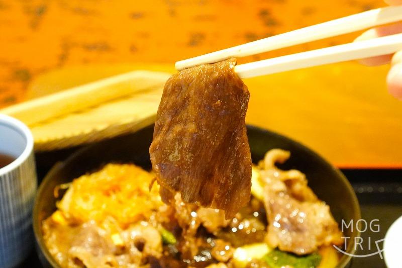 函館にある「すき焼き専門店 阿さ利 本店」の、ランチセットのすき焼きのお肉を箸で持ち上げている様子